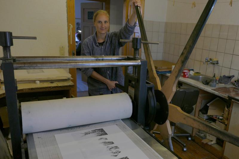 Gastkünstlerin Nana Seeber an der großen Druckerpresse